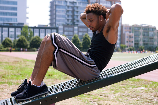 Young man doing sit-ups at outdoor gym