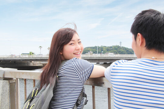 Young couple leaning on railings overlooking river