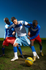 Young men playing football © Image Source Limited