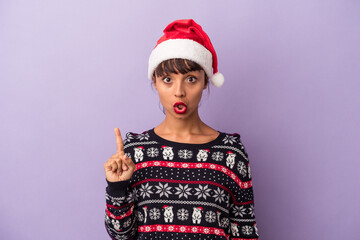 Young mixed race woman celebrating Christmas isolated on purple background  having some great idea, concept of creativity.