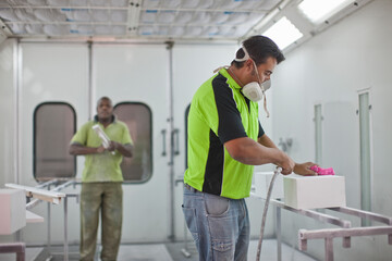 Man spraying box in carpenters workshop