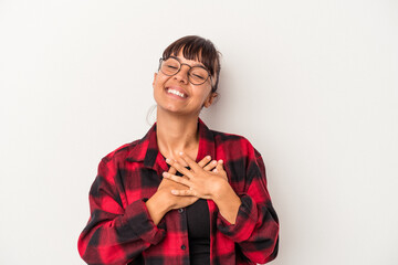 Young mixed race woman isolated on white background  laughing keeping hands on heart, concept of happiness.