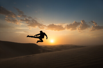 Man jumping mid air, Glamis sand dunes, California, USA