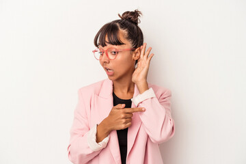 Young mixed race woman isolated on white background  trying to listening a gossip.