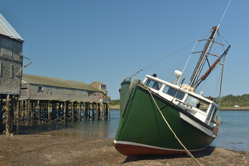 Beached Green Lobster fishing Boat at low tide on the Quoddy Narrows separating the United States...