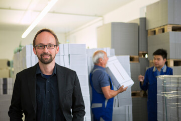 Obraz premium Factory workers moving and stacking cardboard