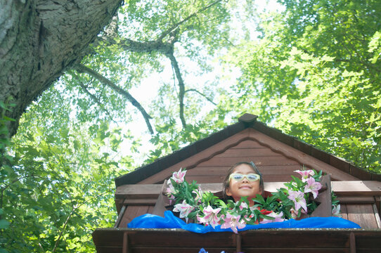 Young girl in tree house, low angle view