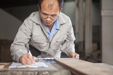 Carpenter measuring wood plank with vernier caliper in factory, Jiangsu, China