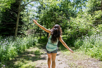 Young woman walking on path through trees