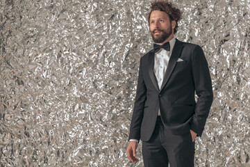 attractive young man in elegant black tuxedo holding hand in pocket