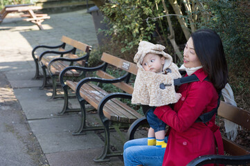 Mother sitting on bench with baby boy