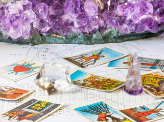 Closeup of birth chart with crystals and tarot deck.