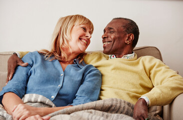 Couple sitting on sofa, smiling