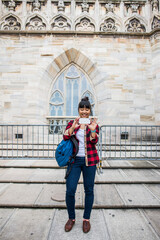 Woman taking selfie in front of Duomo Cathedral, Milan, Italy