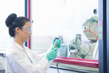 Young female scientist  looking at sample in lab