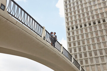 Low angle view of people on footbridge, City Hall East, Los Angeles, California, USA