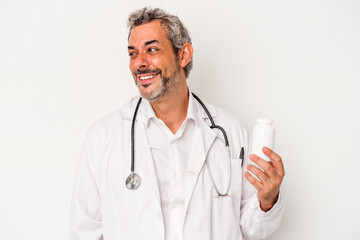 Middle age doctor caucasian man isolated on white background  looks aside smiling, cheerful and pleasant.