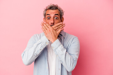 Middle age caucasian man isolated on pink background  shocked covering mouth with hands.
