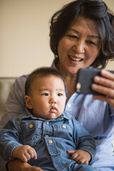 Grandmother showing smartphone to grandson