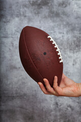 Human hand holding an american football ball