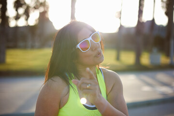 Woman wearing neon vest and sunglasses looking at camera wagging finger