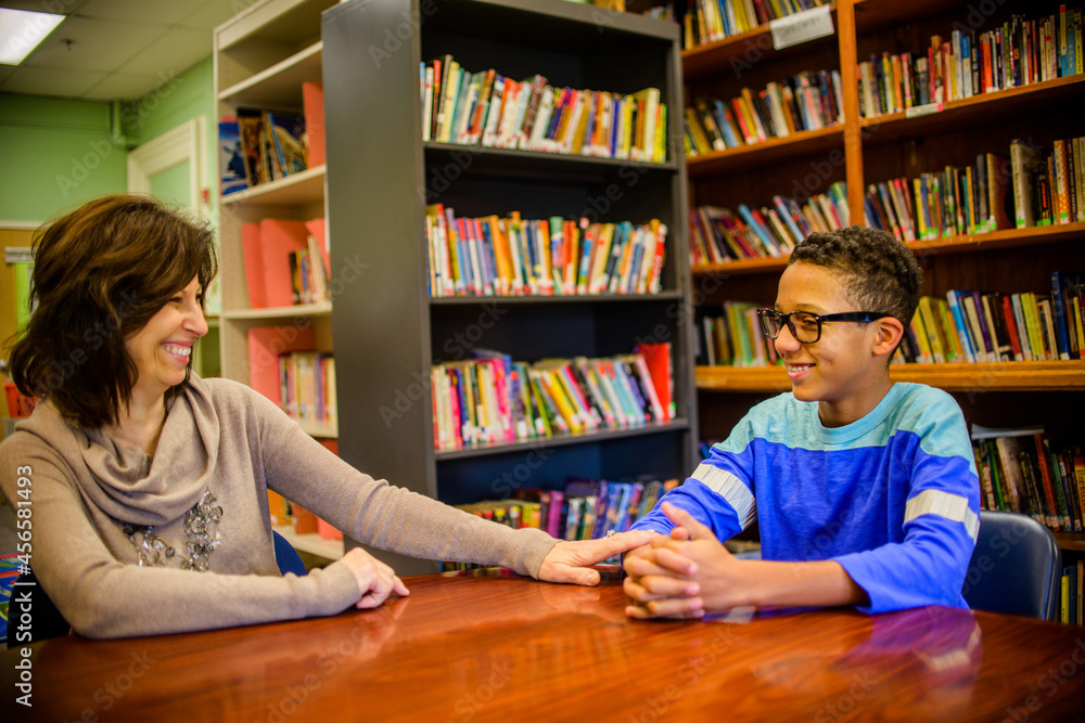 Wall mural Guidance counselor and teenage boy in school library smiling