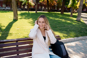 Young scandinavian blonde woman talking on mobile while sitting on a