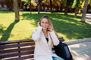 Young scandinavian blonde woman talking on mobile while sitting on a