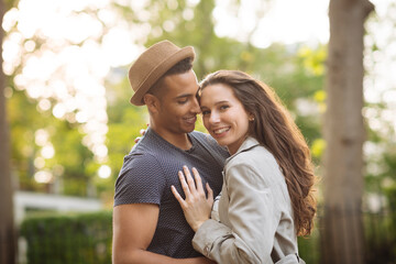 Young couple in street hugging and smiling