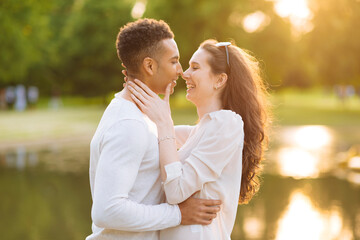 Fototapeta premium Side view of young couple face to face smiling