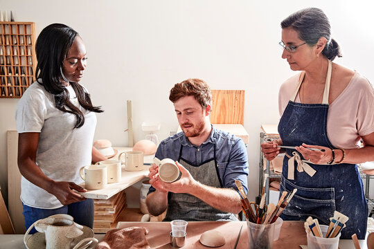 Group of people painting pottery in workshop