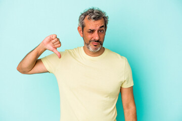 Middle age caucasian man isolated on blue background  showing thumb down, disappointment concept.