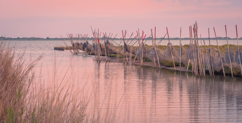 Vue de filets de pêche sur les étangs en Camargue, France au coucher du soleil.	