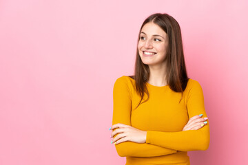 Young caucasian woman isolated on pink background looking to the side