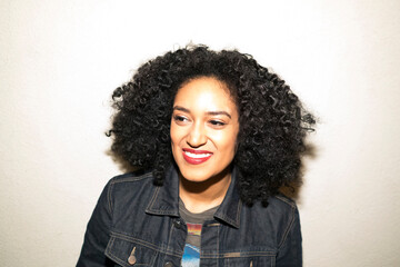 Portrait of curly haired woman looking away smiling