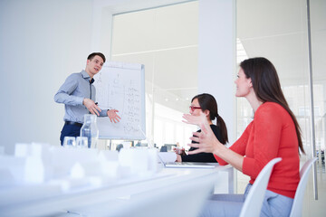 Colleagues in architect office with architectural model