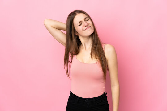 Young caucasian woman isolated on pink background with neckache © luismolinero