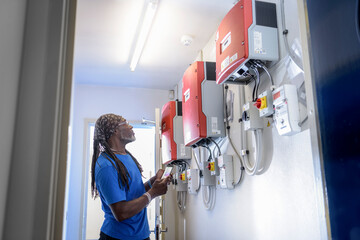 Community worker using smartphone app to check heat pump energy controls