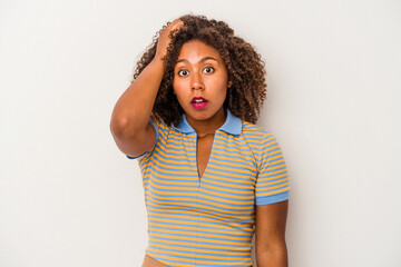 Young african american woman with curly hair isolated on white background being shocked, she has...