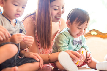 Mother showing crayon drawing to baby boy on dining room table