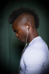 Profile of young man with mohawk wearing earphones