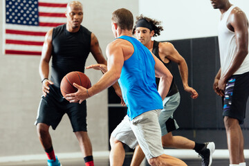 Male basketball player running with ball in basketball game