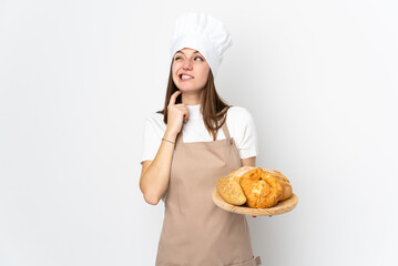 Young woman in chef uniform isolated on white background thinking an idea