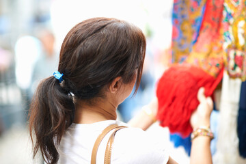 Rear view of woman looking at red textiles on market stall, Sintra, Portugal