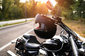 Motorcycling as a way of life, image of parked bike on the road with helmet hanging from the...