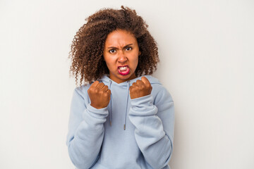 Young african american woman with curly hair isolated on white background upset screaming with...