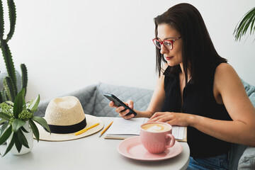 Young beautiful woman at a table in a cafe talking on the phone. 