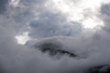 Naklejka na ściany i meble un panorama di montagna ricco di nuvole, una brutta giornata di montagna con le nuvole dense sopra il bosco