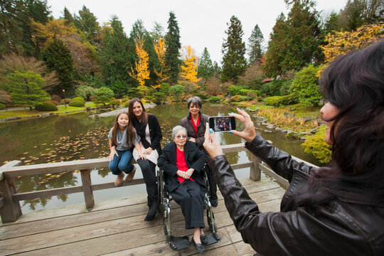 Woman photographing multi generation family