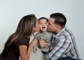 Mother and father kissing toddler son